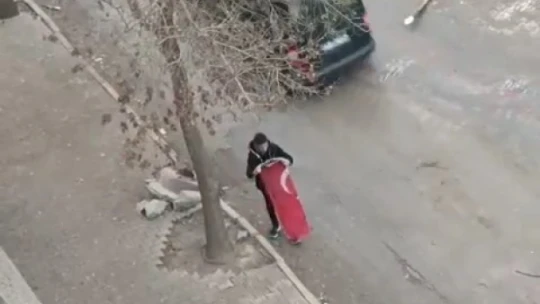 Yerdeki Türk bayrağını önce kaldırıp öptü, ardından yıkayıp balkona astı